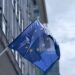 Drapeau de l'Union europeenne devant un batiment institutionnel