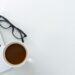 Laptop, coffee and glasses on a desk for remote work