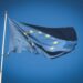 European Union flag flying on a flagpole against a blue sky